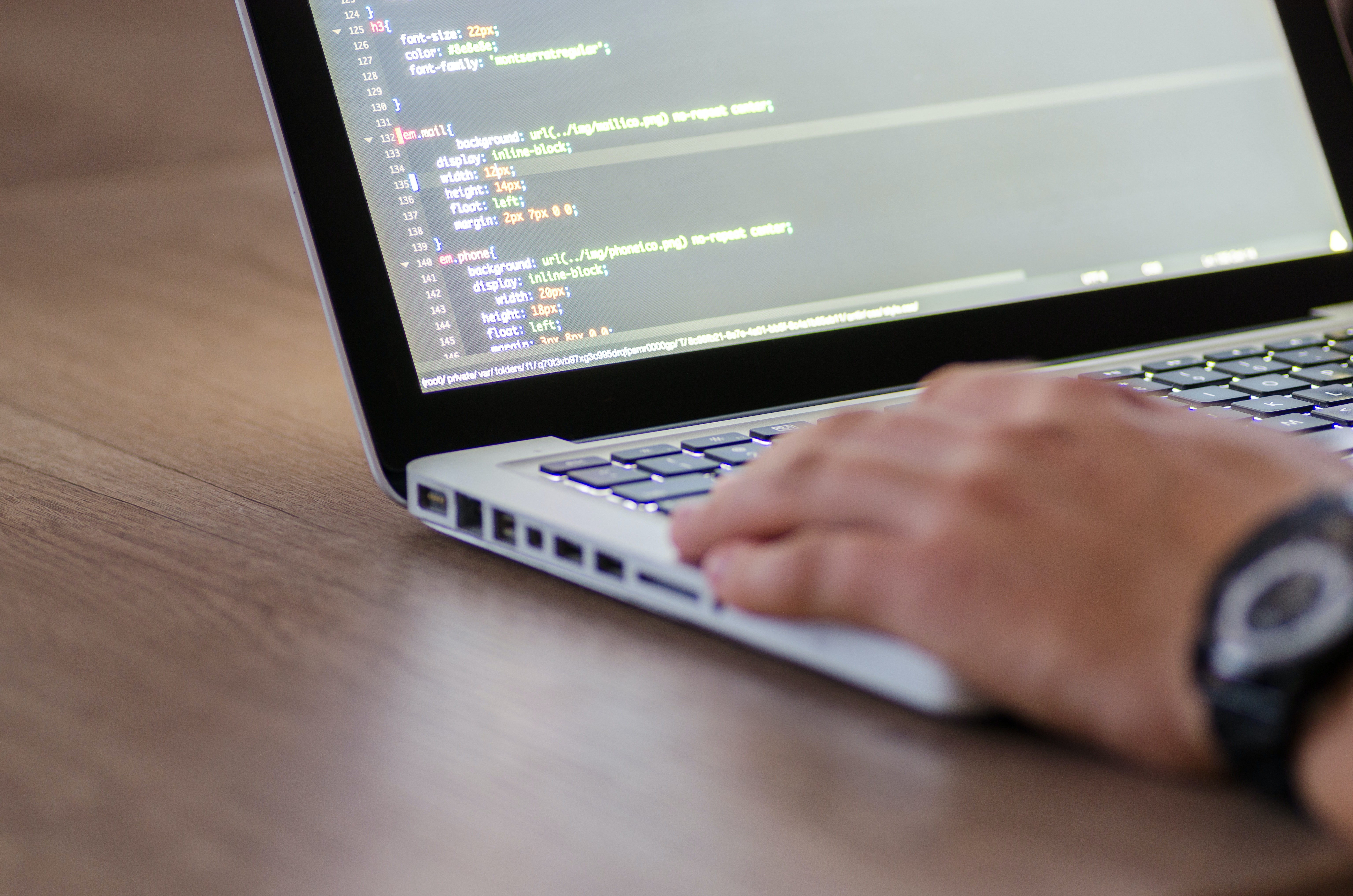 Code Audit - photo of a person's hand typing on a laptop